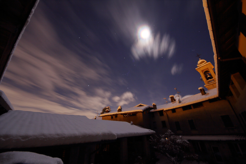 Neve sui tetti di Bartesate in una notte di luna piena.